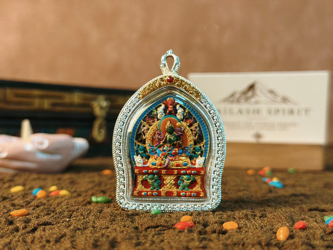 Green Tara Tsa Tsa Gau pendant, front view on textured brown cloth.