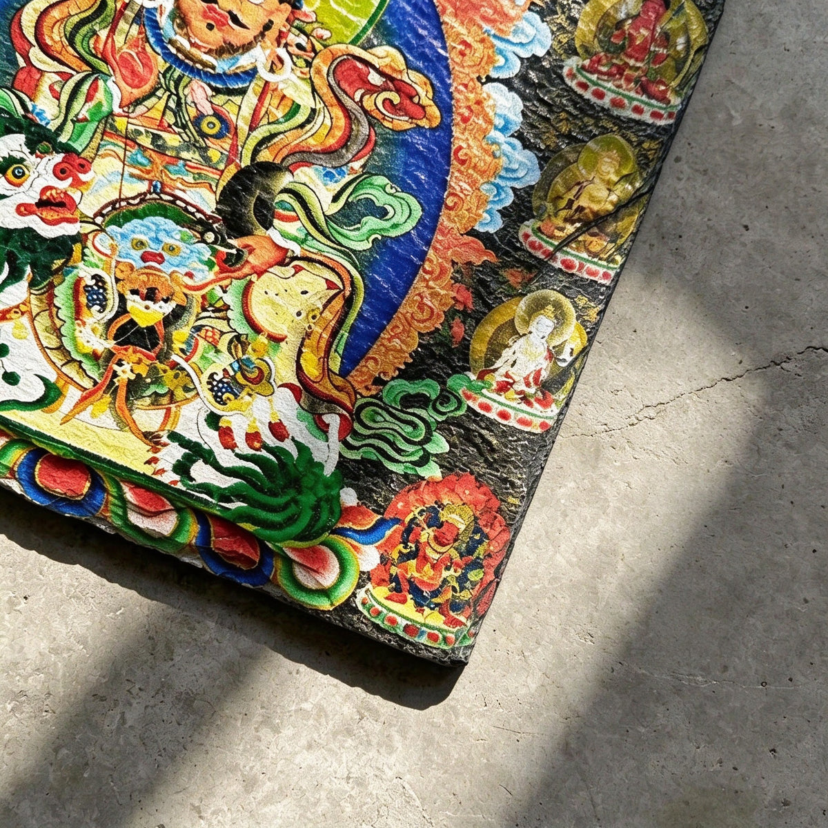 Vaishravana on snow lion black slate art tile, close-up of the printed details, surface texture and slate edge.