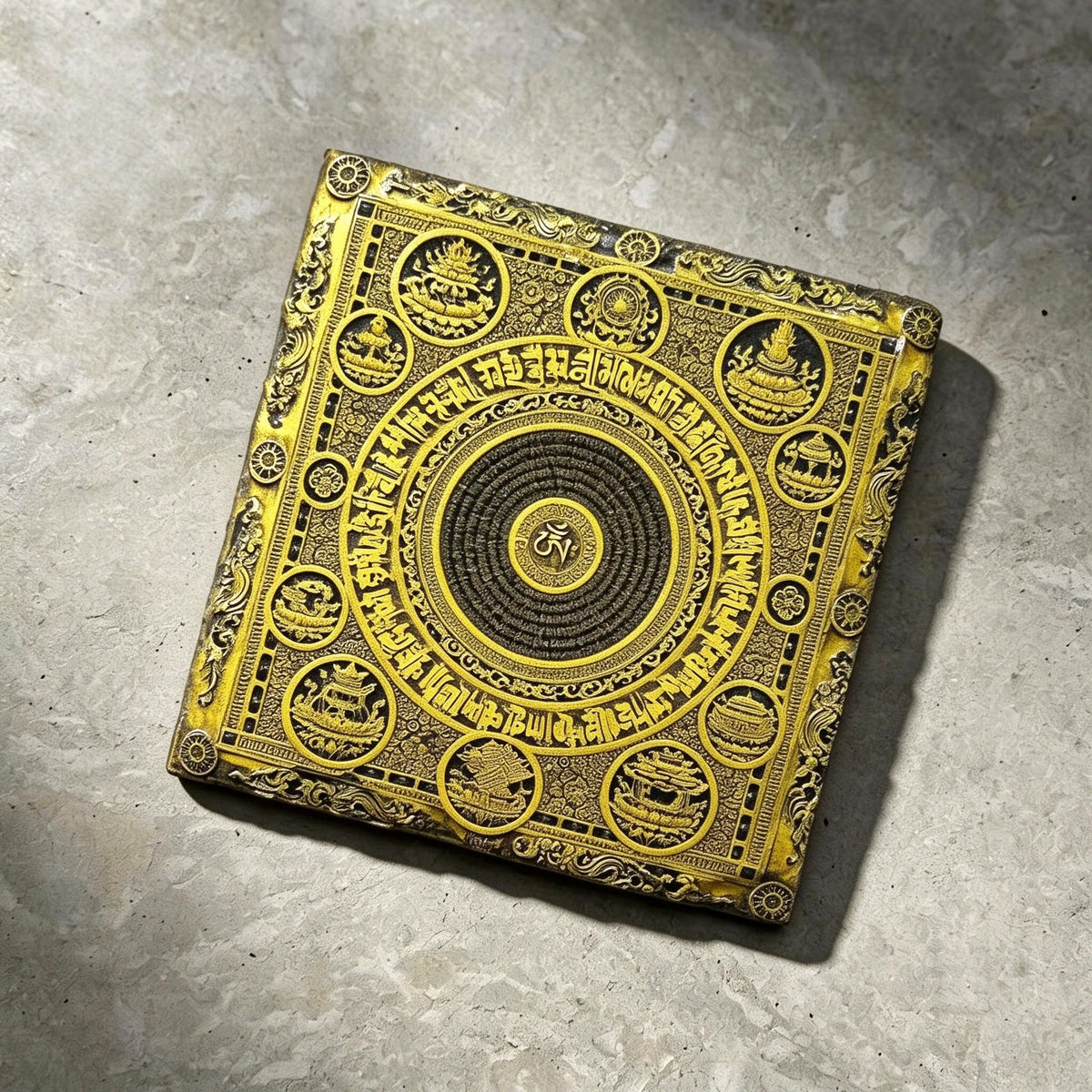 Tibetan Buddhist mandala black slate art tile, angled view showing the printed face and slate thickness.