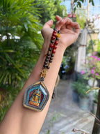 Jowo Rinpoche pendant necklace held against an arm for scale