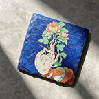 Lotus and hand black slate art tile, angled view showing the printed face and slate thickness.