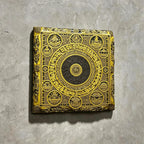 Tibetan Buddhist mandala black slate art tile, angled view showing the printed face and slate thickness.