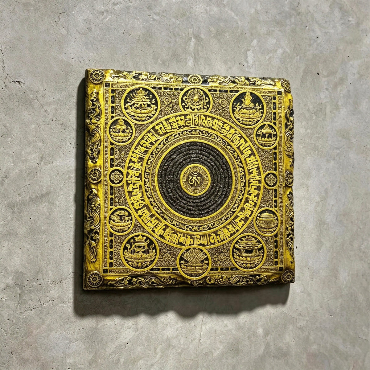 Tibetan Buddhist mandala black slate art tile, angled view showing the printed face and slate thickness.