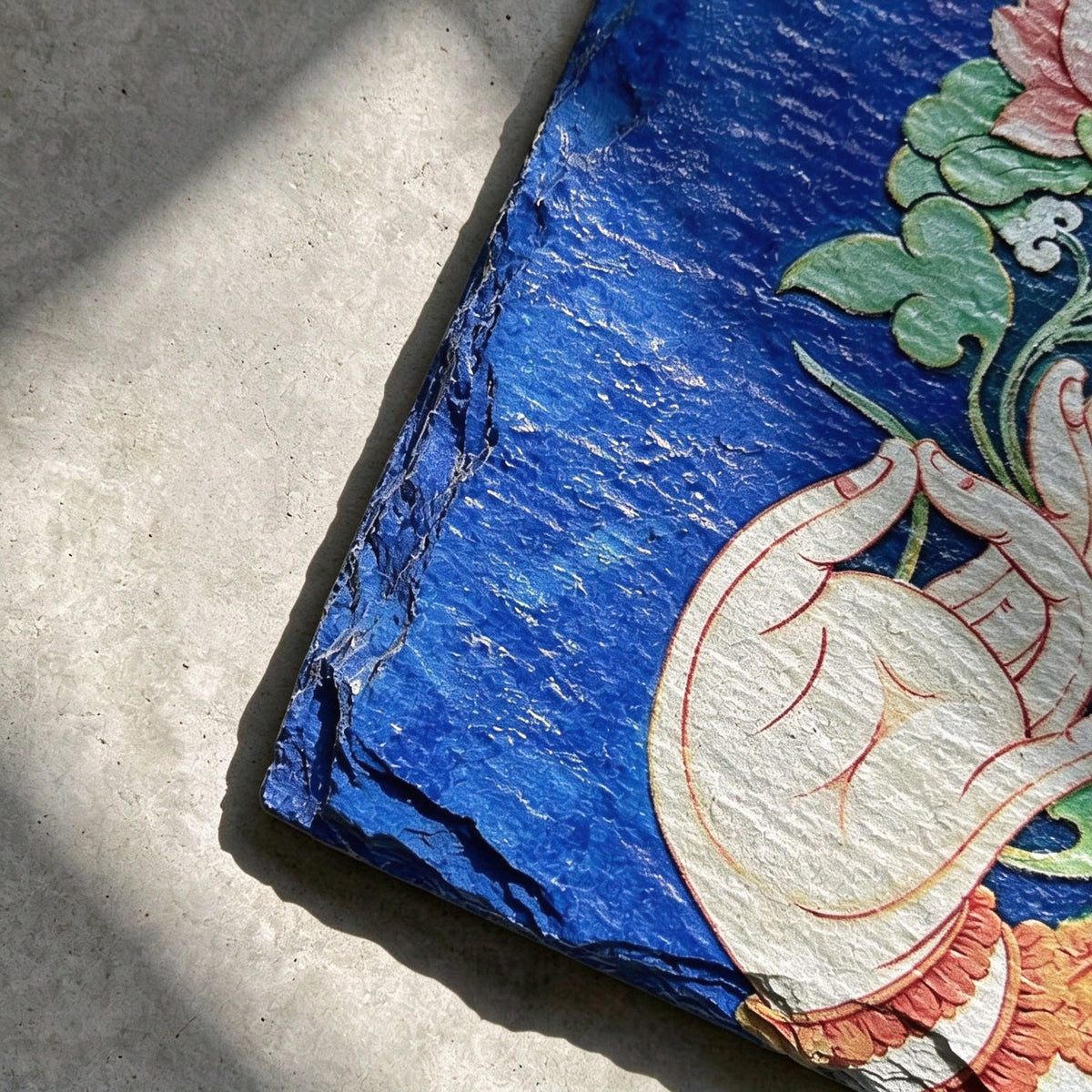 Lotus and hand black slate art tile, close-up of the printed details, surface texture and slate edge.