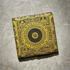 Tibetan Buddhist mandala black slate art tile, angled view showing the printed face and slate thickness.