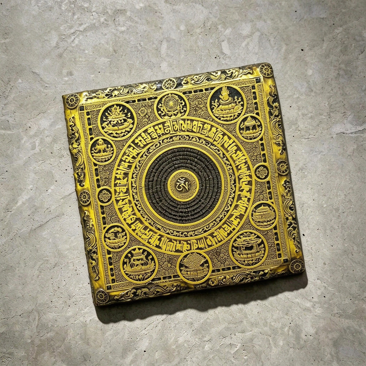 Tibetan Buddhist mandala black slate art tile, angled view showing the printed face and slate thickness.