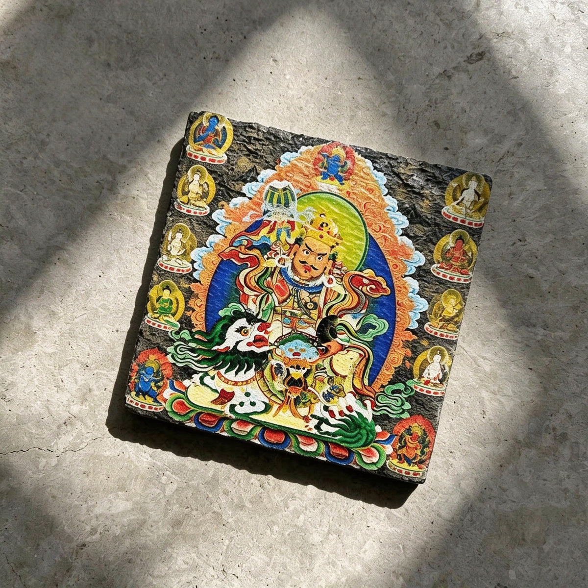 Vaishravana on snow lion black slate art tile, angled view showing the printed face and slate thickness.