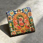 Red Jambhala black slate art tile, angled view showing the printed face and slate thickness.