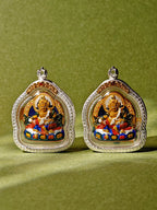 Two Yellow Dzambhala pendants displayed side by side