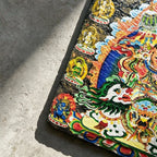 Vaishravana on snow lion black slate art tile, close-up of the printed details, surface texture and slate edge.