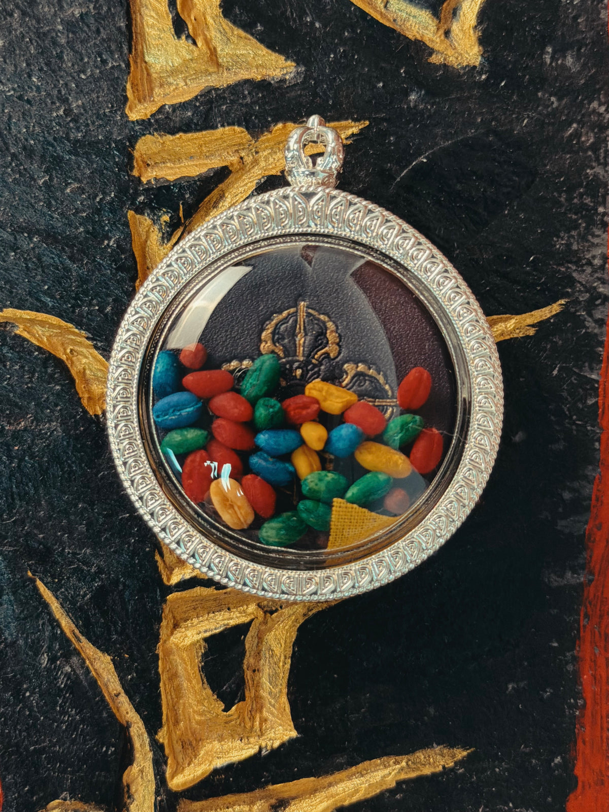 Transparent reverse of Ksitigarbha pendant showing colorful internal materials