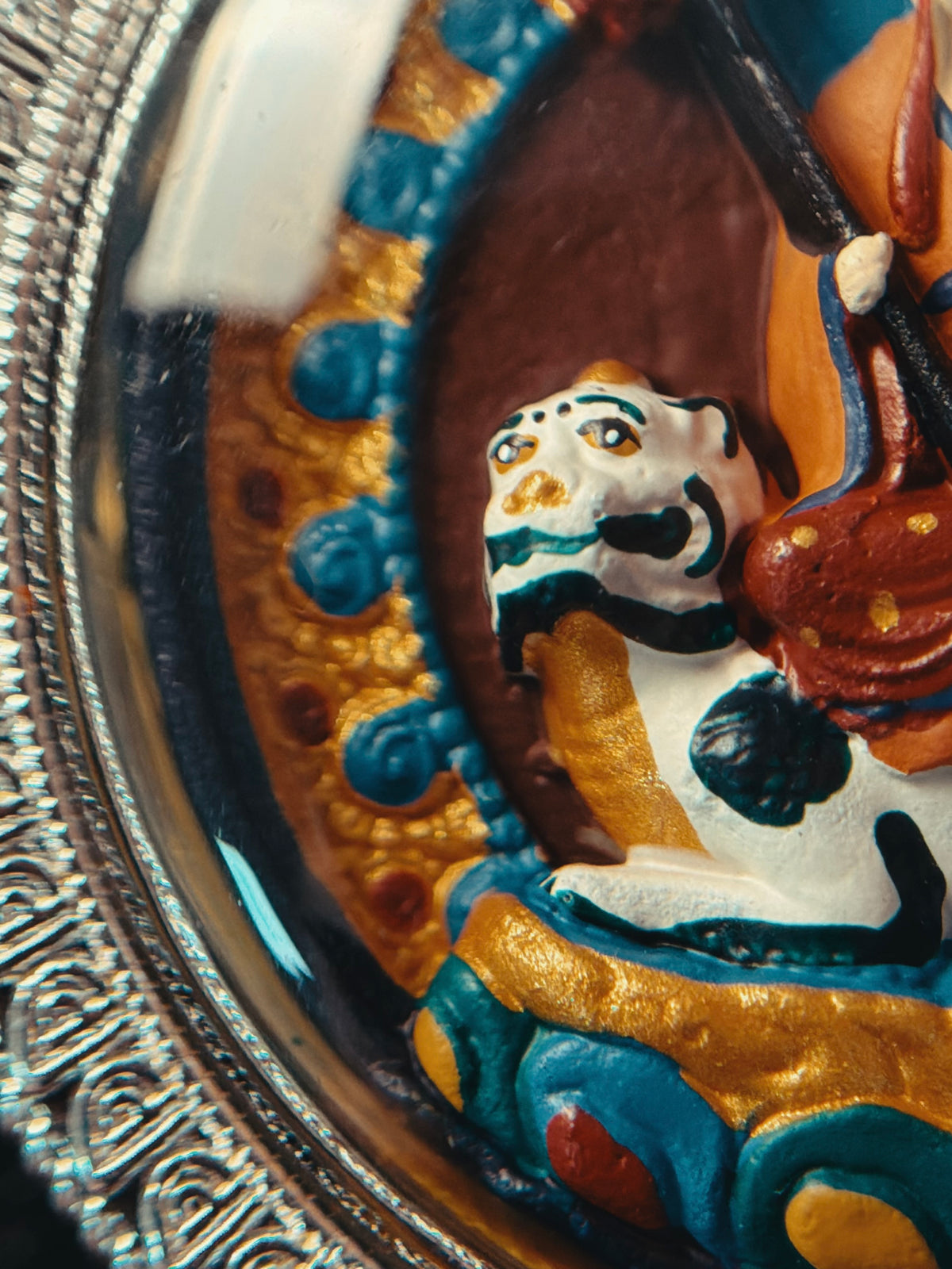 Close-up of the painted animal figure and blue border on Ksitigarbha relief