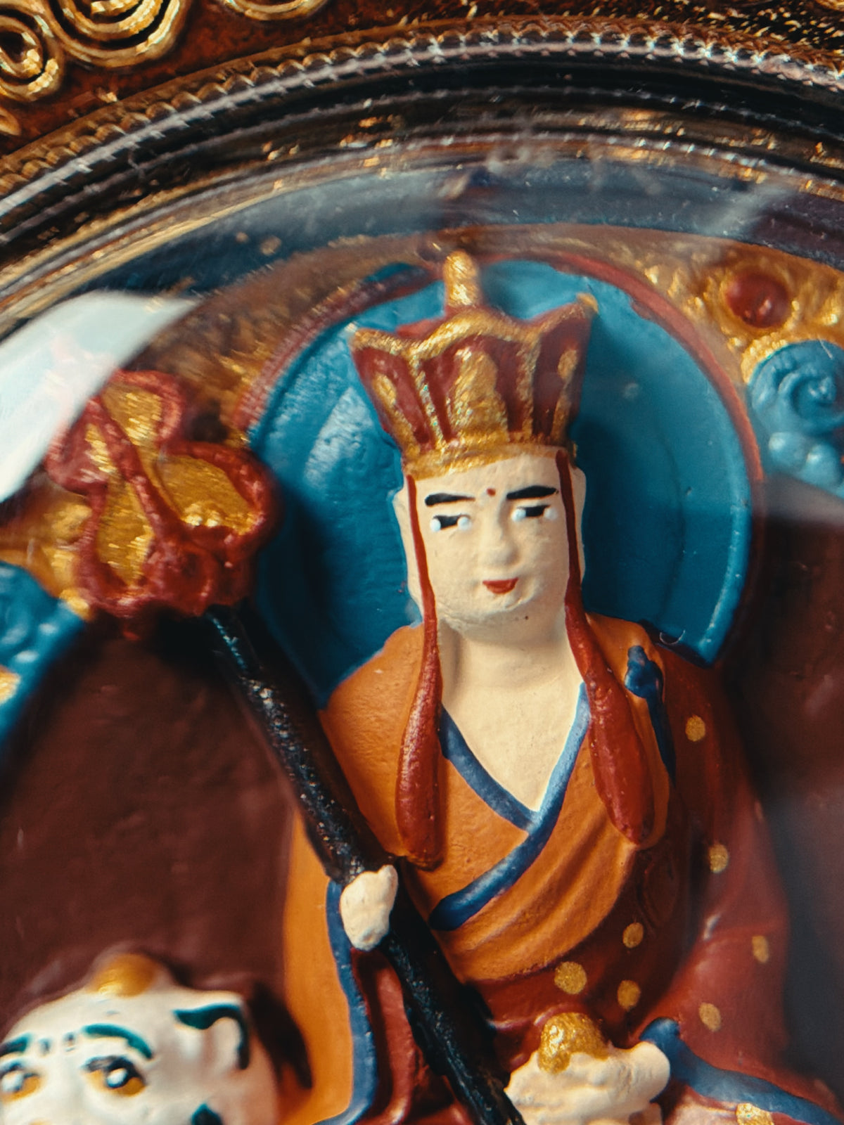 Close-up of Ksitigarbha's face and headdress beneath the gau case rim