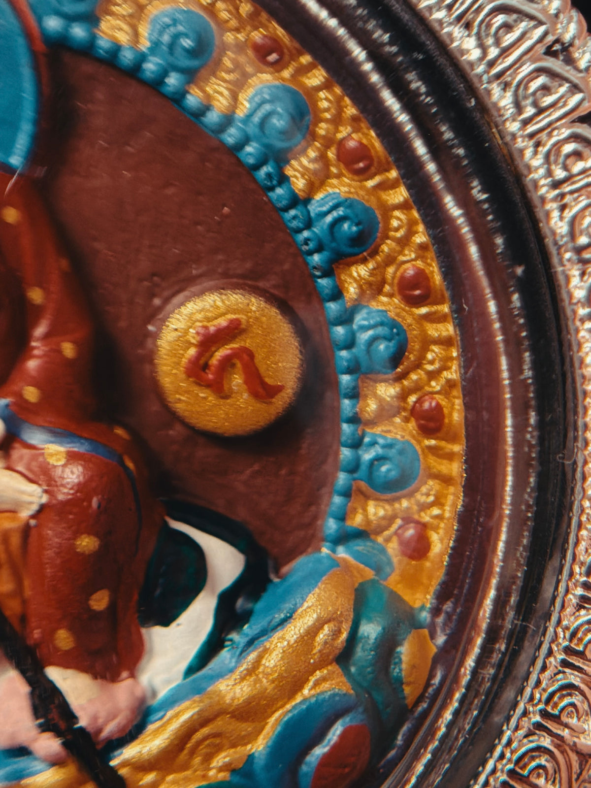 Close-up of the painted robe and decorative blue border on Ksitigarbha relief